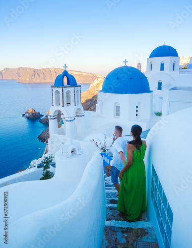 A couple walking at the village of Oia Santorini Greece, men and women visit the whitewashed Greek village of Oia during summer vacation