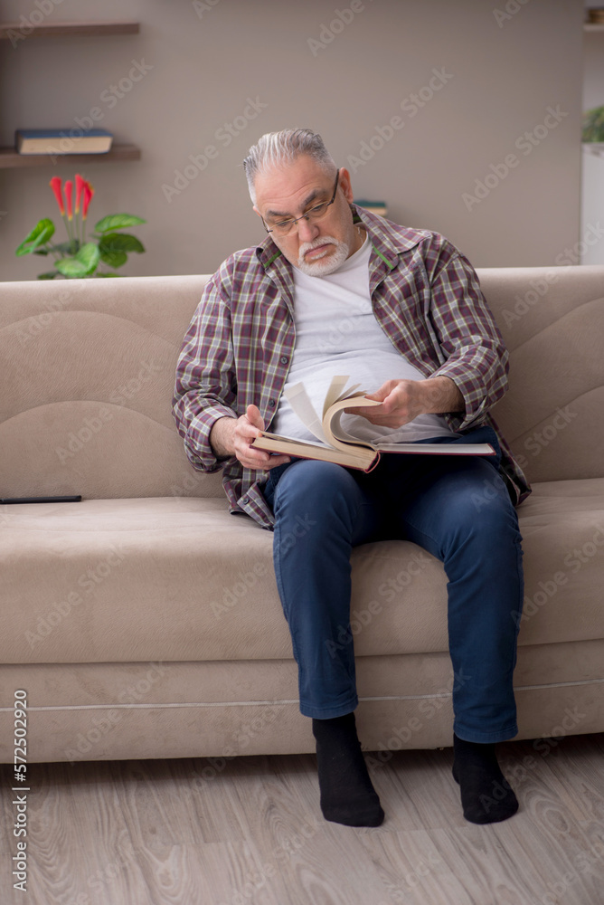 Old man reading book at home Old man reading book at home