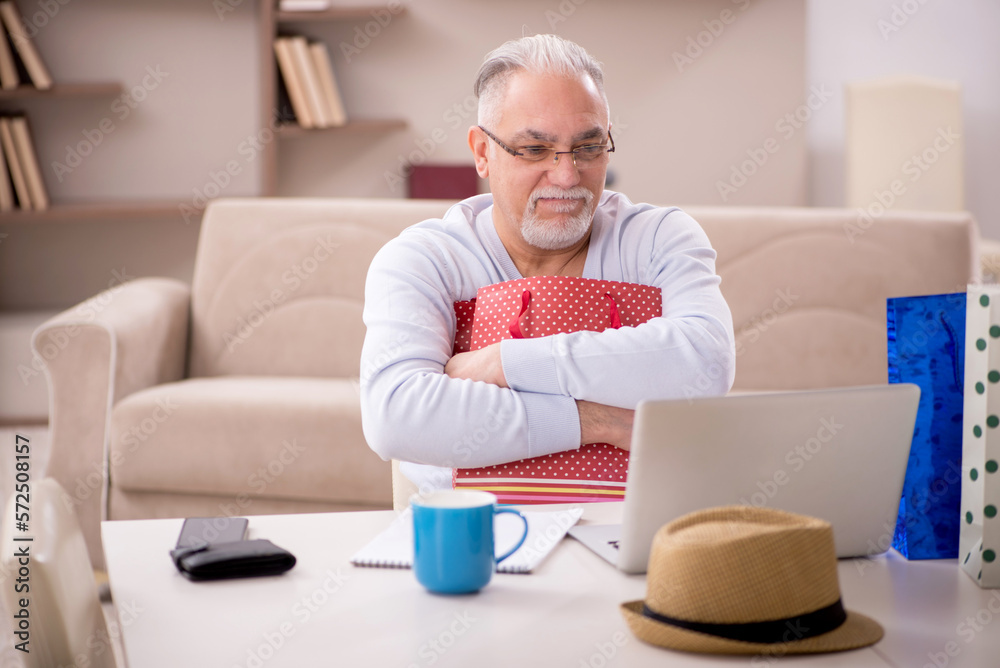 Old man with many bags in Christmas concept at home Old man with many bags in Christmas concept at home