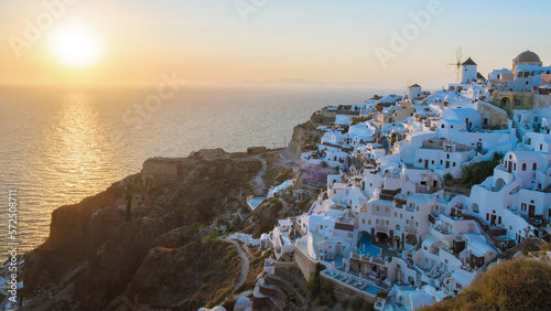 sunset with white churches an blue domes by the ocean of Oia Santorini Greece, a traditional Greek village in Santorini.  photo