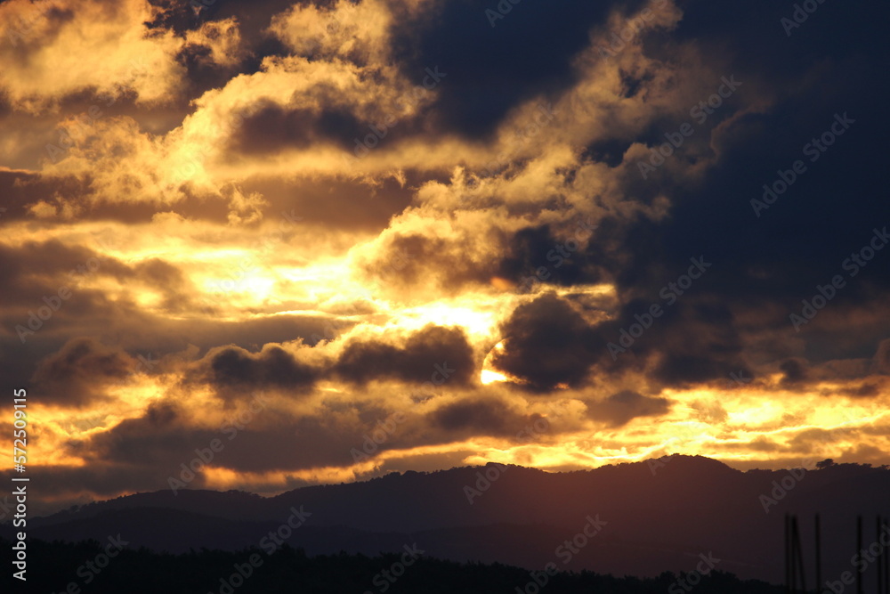 red sunset sky in the clouds, golden hour abstract clouds, sun behind clouds, hard shadows