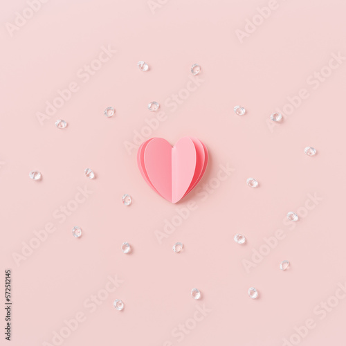 Heart with sequins, rhinestones around on pastel pink background, St. Valentine Day, love or wedding day concept. Cut pink paper heart as symbol romantic relationships, minimal aesthetic