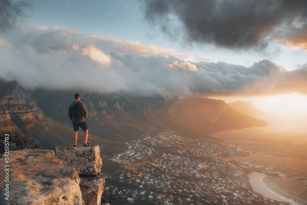 Young man standing on the top of the rock. Success, achieved goal concept, Photo taken in Cape Town, South Africa - obrazy, fototapety, plakaty 