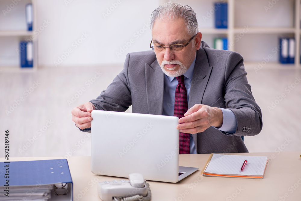 Old male employee working in the office