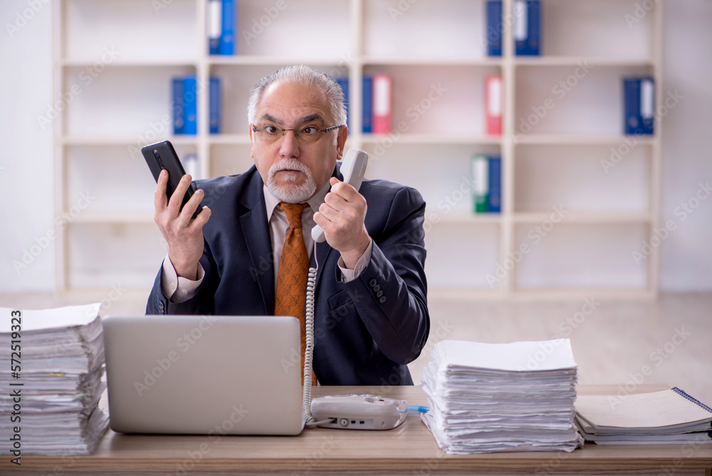 Old male employee and too much work in the office Old male employee and too much work in the office