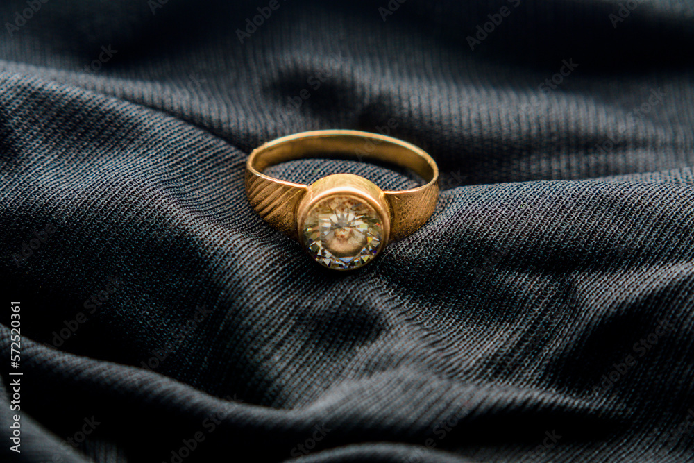 Gold ring with zircon stones placed on black velvet cloth Gold ring with zircon stones placed on black velvet cloth