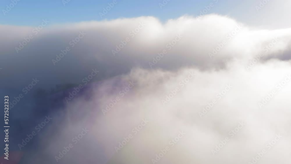 Aerial view flying over Santa Cruz rolling fog clouds with landscape emerging through mist Aerial view flying over Santa Cruz rolling fog clouds with landscape emerging through mist