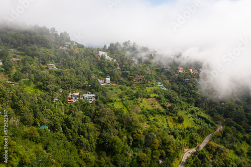 Houses on the slopes of mountains covered with fog and clouds. Ella, Sri Lanka. © Alex Traveler