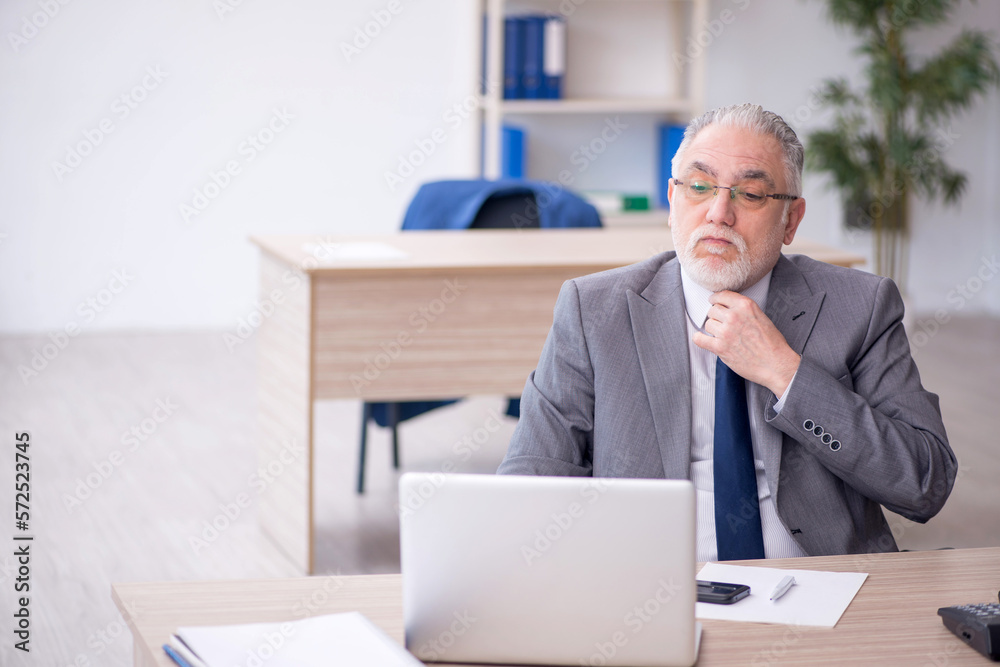 Old male employee working in the office Old male employee working in the office