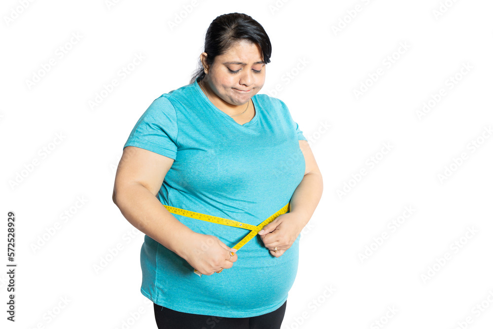 Sad overweight indian woman check belly fat with measuring tape isolated over white background. Dieting and weight loss, Mental health. Sad overweight indian woman check belly fat with measuring tape isolated over white background. Dieting and weight loss, Mental health.