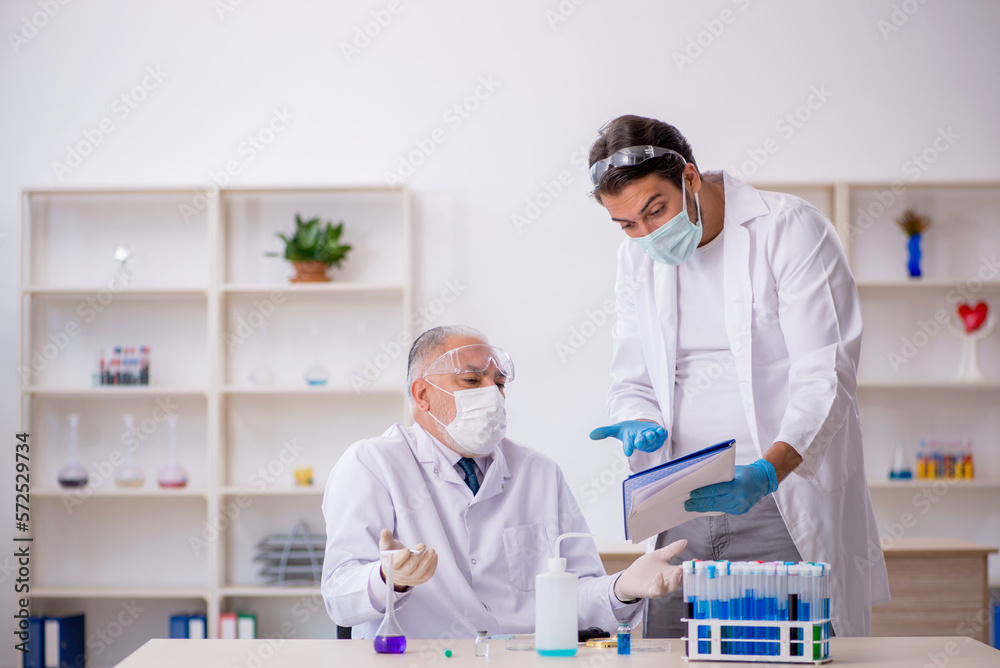 Two male chemist working at the lab Two male chemist working at the lab