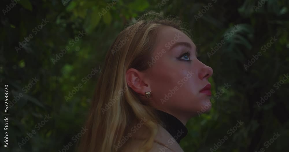 Woman with deep eyes turn around while walking in jungle area, close up back view Woman with deep eyes turn around while walking in jungle area, close up back view