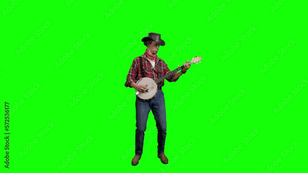Man In Hat Plays Ukulele On Green Background. Man In Hat Plays Ukulele On Green Background.
