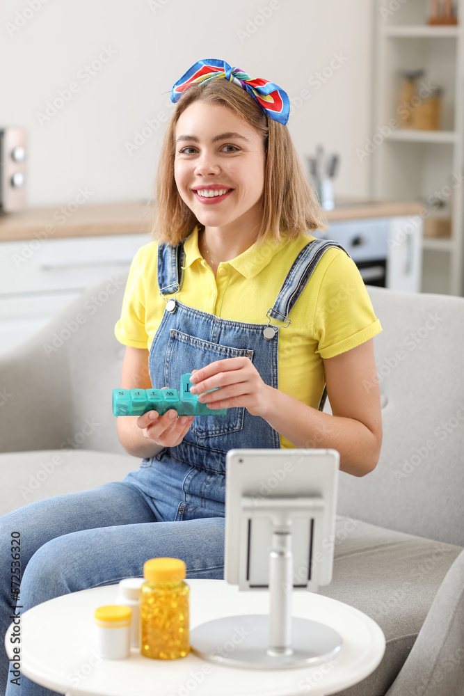 Young woman with container of vitamin supplements at home Young woman with container of vitamin supplements at home