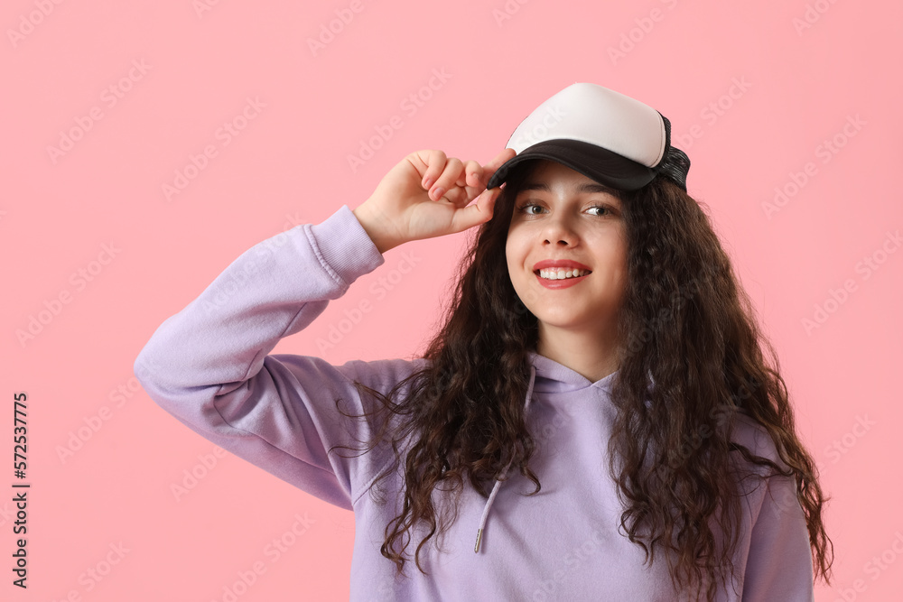 Teenage girl in cap on pink background Teenage girl in cap on pink background