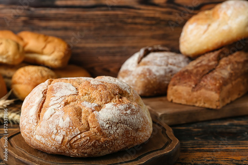 Cutting board with loaf of fresh bread on wooden table