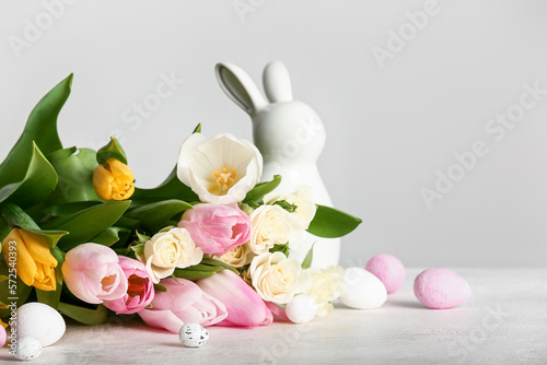 Sticker Beautiful flowers, Easter eggs and ceramic bunny on light background