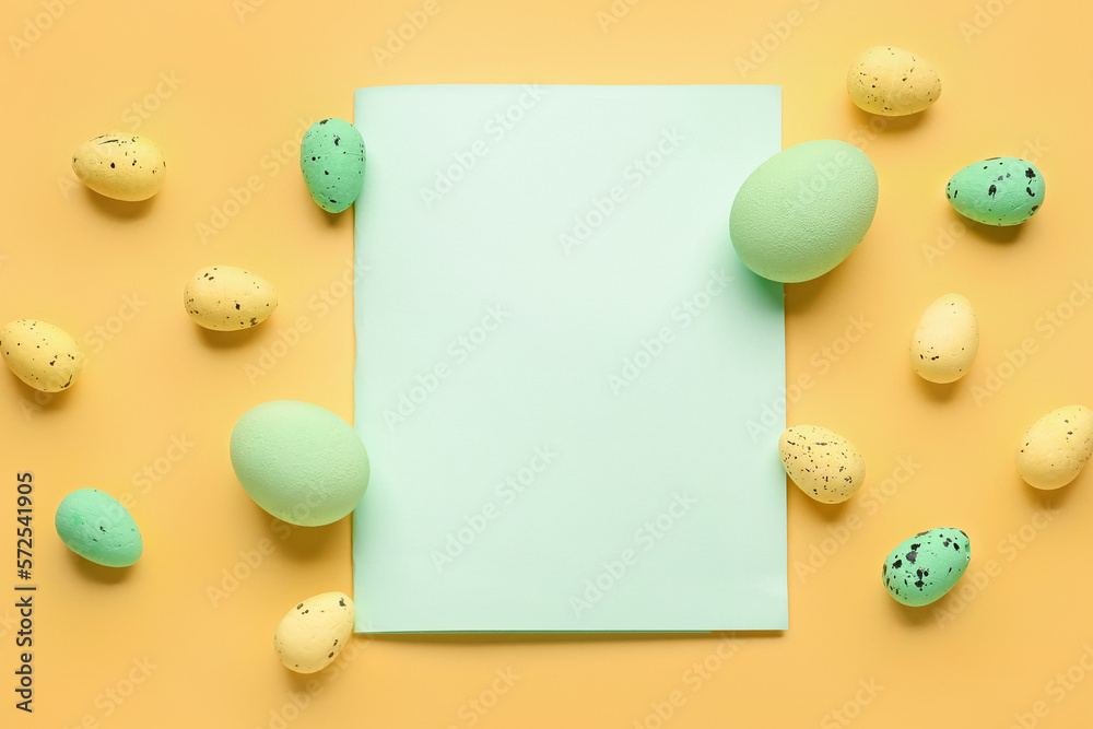 Composition with blank card and painted Easter eggs on yellow background Composition with blank card and painted Easter eggs on yellow background