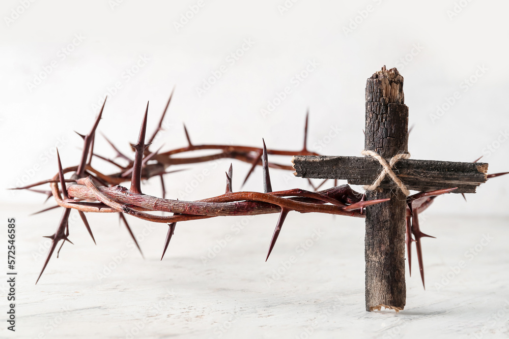 Wooden cross with crown of thorns on light background. Good Friday concept Wooden cross with crown of thorns on light background. Good Friday concept