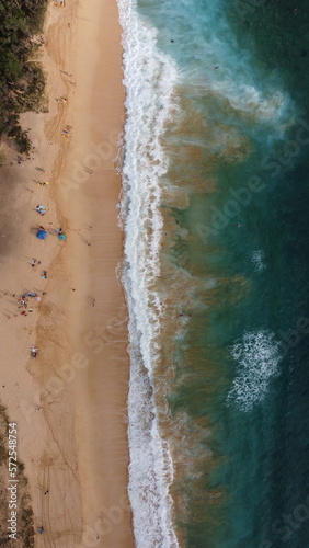 Top view of beautiful beach. Aerial drone shot of turquoise sea water at the beach - space for text. Hawaiian seaside beach with turquoise water and big waves aerial view.