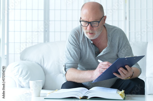 senior old man with book working at home
