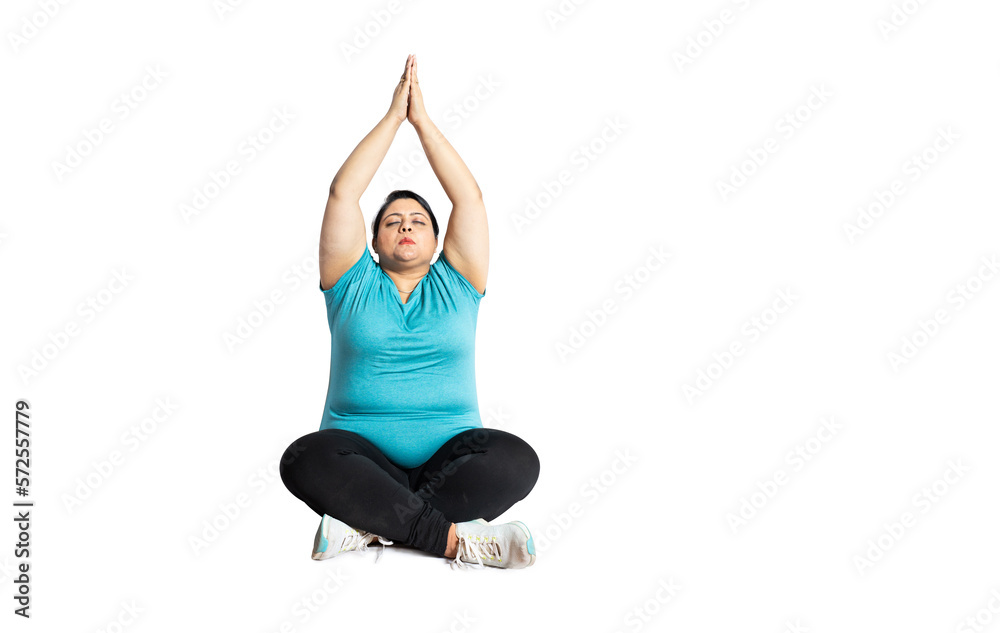 Fat indian woman doing meditation yoga exercise while siting on floor isolated over white background, Copy space. Overweight asian lady. Weight lose and healthcare concept. Fat indian woman doing meditation yoga exercise while siting on floor isolated over white background, Copy space. Overweight asian lady. Weight lose and healthcare concept.