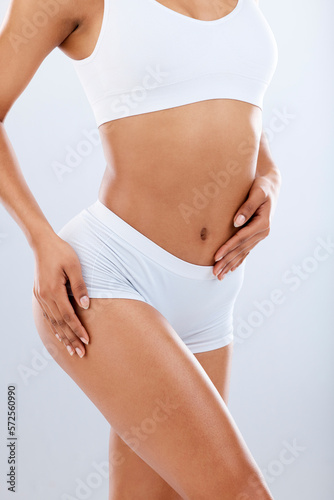 Slim, attractive and body shape of a woman in underwear isolated on a grey studio background. Skin, sexy and girl model showing curves, exercise results and figure after a workout on a backdrop