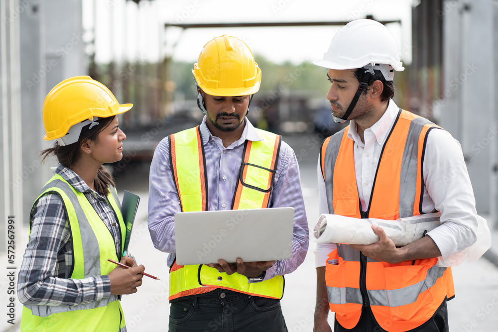 India engineer man holding laptop computer with team engineer at precast site work India engineer man holding laptop computer with team engineer at precast site work
