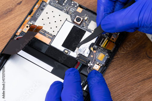 close-up of a specialist's work on replacing an electronic board and disconnecting contacts for a new one, repair