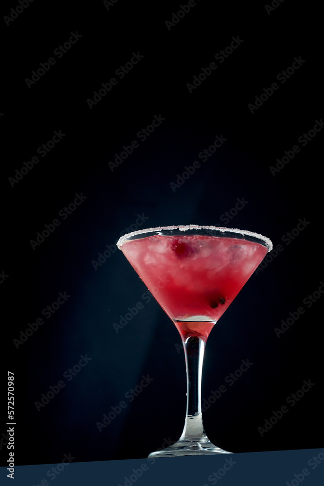 Alcoholic pink cocktail with cranberry and ice in a glass. Concrete background. Vermouth with vodka