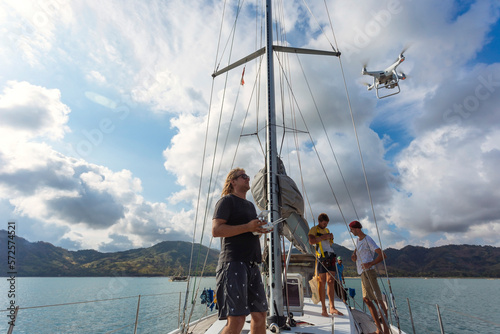 Man flying drone on sailboat, Lombok, Indonesia photo