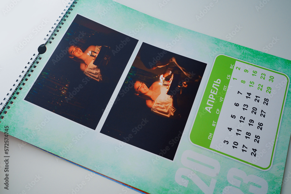 Obraz premium a flip calendar with family photos. teen girl blows out candles on cake