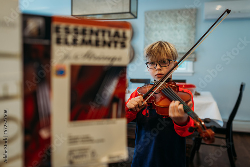 Boy playing a viola with music book in front