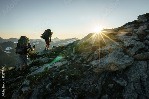 Silhouette of two hikers at sunset with mountains in background, BC