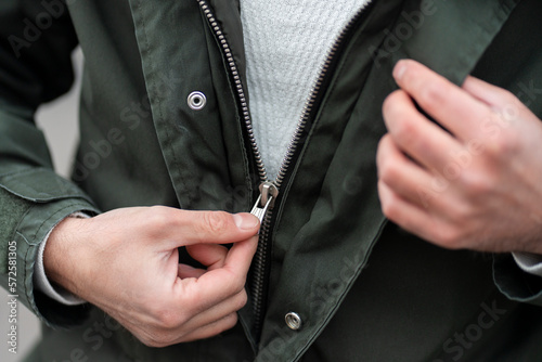 Photography Close up view of a man unzipping his jacket.
