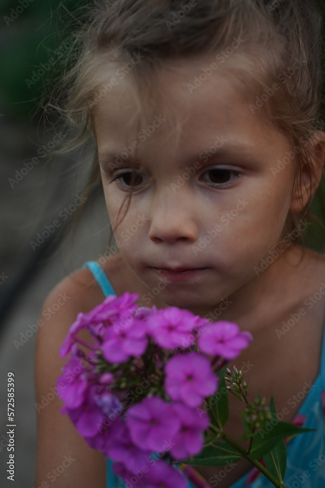 Fototapeta premium Photo of happy young woman in dress holding bouquet with flowers while walking outdoor. Selective focus
