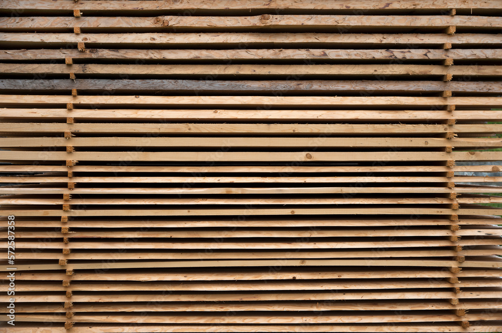 Stacked planks of raw wood in the open air for drying like a background Stacked planks of raw wood in the open air for drying like a background