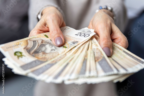 Kobieta trzyma w dłoniach banknoty, pieniądze polskie, złotówki. Liczenie pieniędzy.