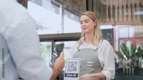 Female worker takes payment via QR code from a customer man who comes to shop, Cashless technology and online shopping concept