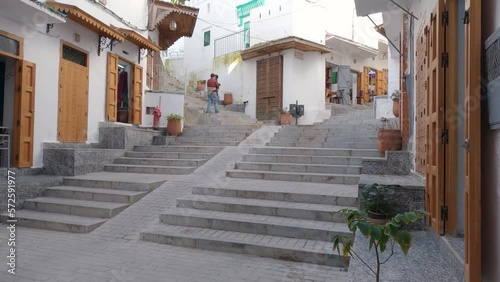 View Looking Up Steps In Street With Tourist Taking Photograph In The Background In Tangier. Slow Pan Up