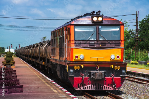 Tanker-freight train by diesel locomotive passed the railway station.