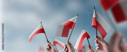 A group of people holding small flags of the Poland in their hands
