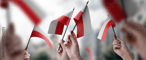 A group of people holding small flags of the Poland in their hands