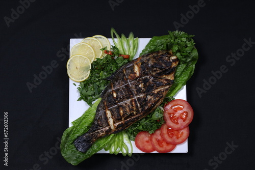 Grilled Fish Served with Parsly Lettuce Tomato Lemon and Pepper Slices -  Seafood Dishes