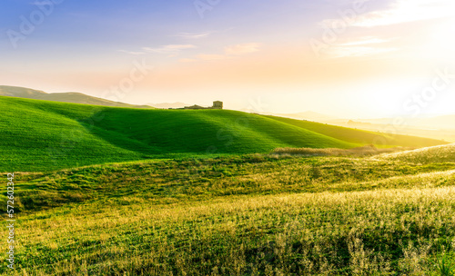 scenery rural view of a contryside farm in green fields and hills with amazing cloudy sky on background