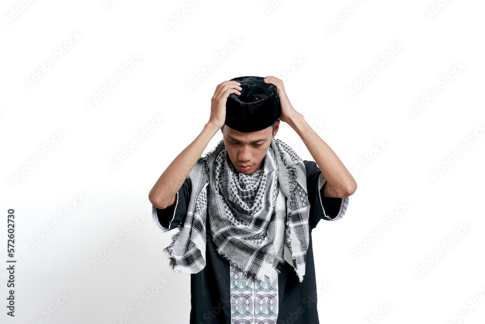 Religious Muslim Asian man wearing a turban, Muslim dress and preparing to wear a cap. Isolated on white background. Religious Muslim Asian man wearing a turban, Muslim dress and preparing to wear a cap. Isolated on white background.