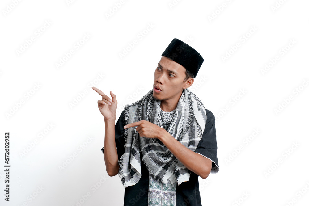 Religious muslim asian man wearing turban, muslim dress and cap, pointing to the side of empty space. Isolated on white background. Religious muslim asian man wearing turban, muslim dress and cap, pointing to the side of empty space. Isolated on white background.