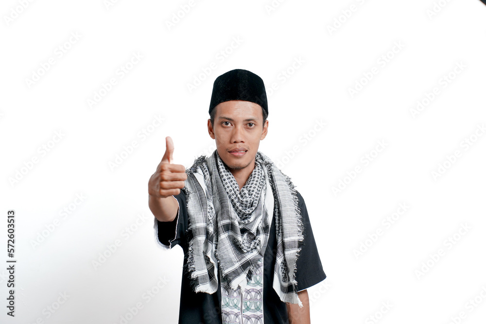 Religious muslim asian man wearing turban, muslim dress and cap, showing thumbs up that he agrees. Isolated on white background. Religious muslim asian man wearing turban, muslim dress and cap, showing thumbs up that he agrees. Isolated on white background.
