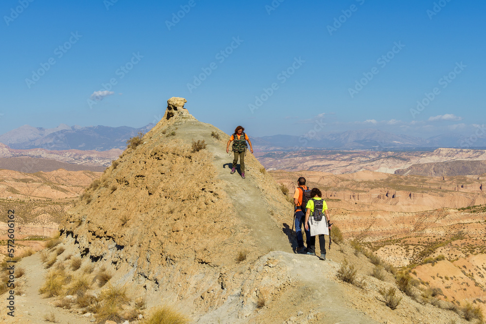 Hikers walk to the top of the mountain to see the desert landscape of Gorafe.