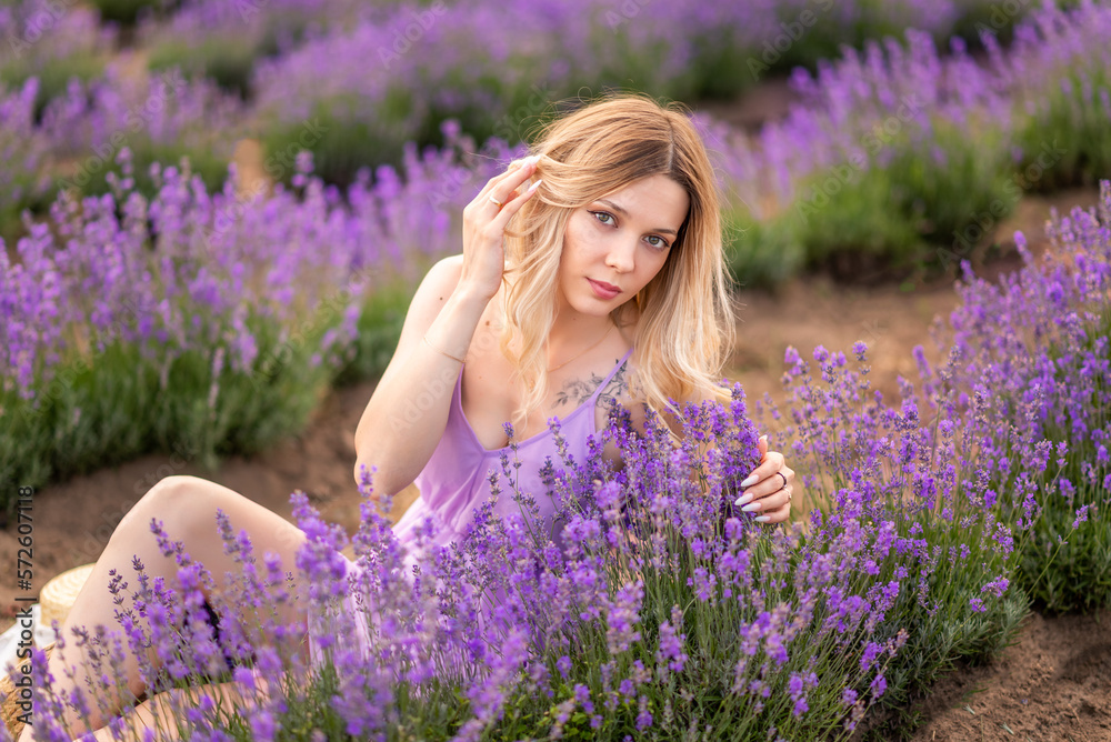 Blonde girl inhales the scent of lavender flowers Blonde girl inhales the scent of lavender flowers